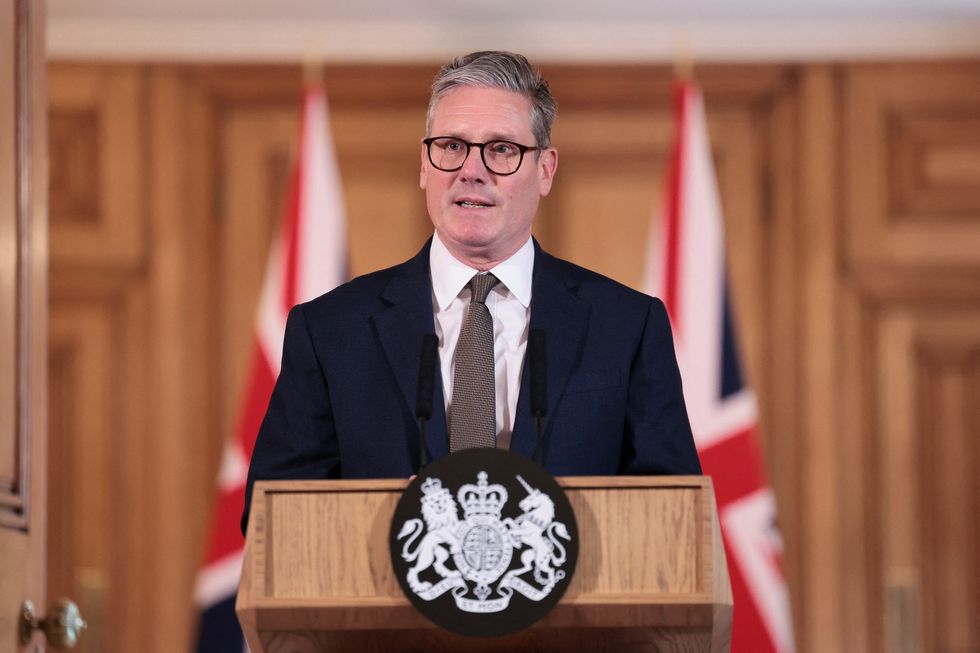 keir starmer stands in front of a podium in downing street for a press conference