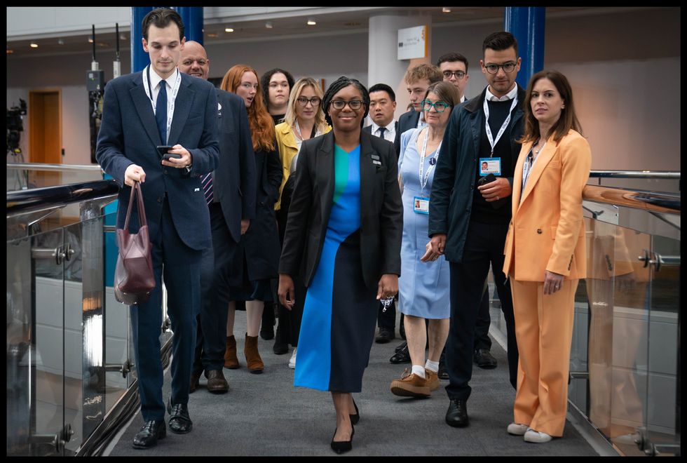 Kemi Badenoch walks with her team through the Birmingham International Conference centre