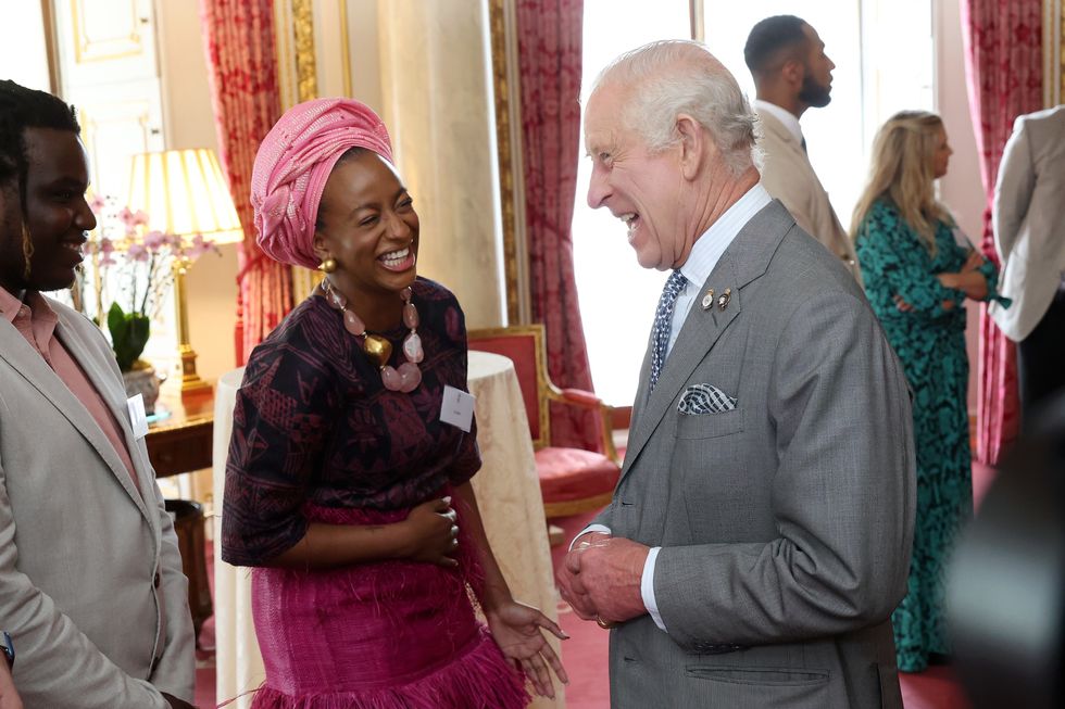 King Charles III meets DJ Cuppy (centre), during a reception for Prince's Trust Award 2024 winners