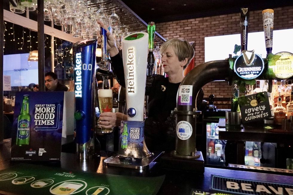 Lilian Greenwood pulling a pint of Heineken 0.0