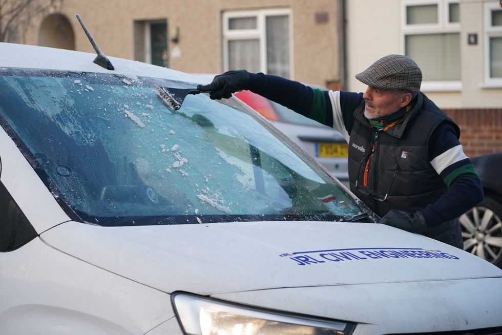 Man defrosting his car windscreen