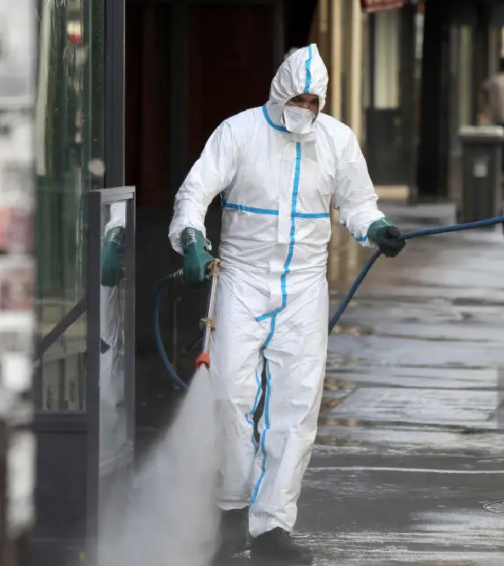 Man fumigating in hazmat suits