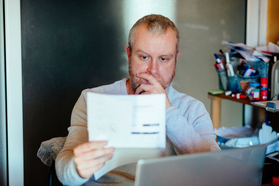 Man looks worried at bank statement