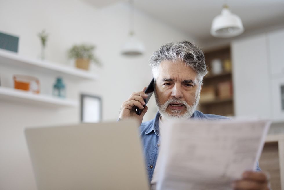 Man on phone looking at letter