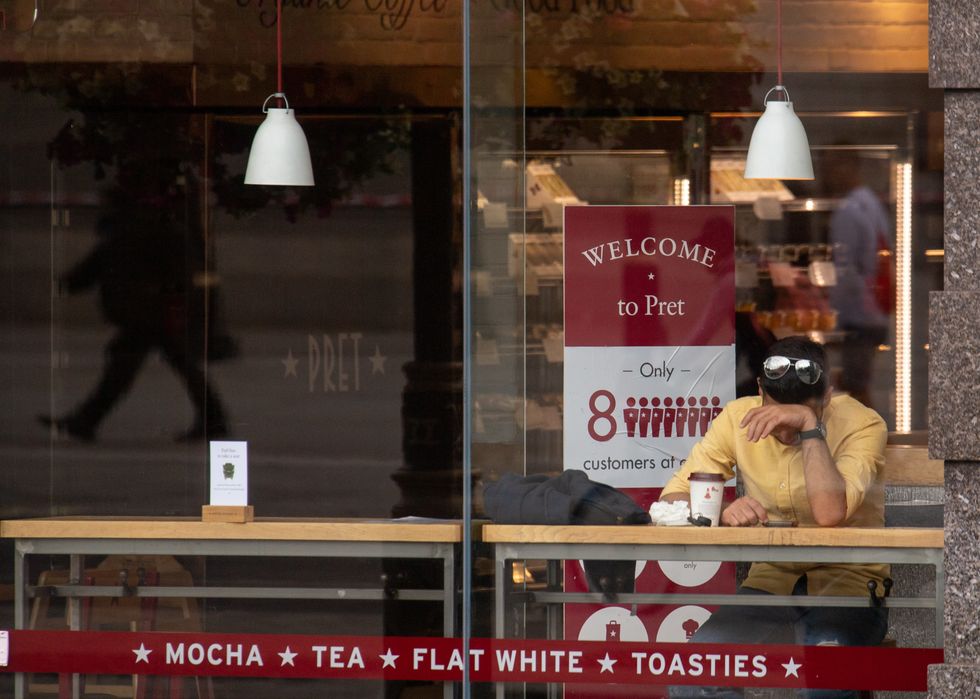 Man sitting outside Pret A Manger in London