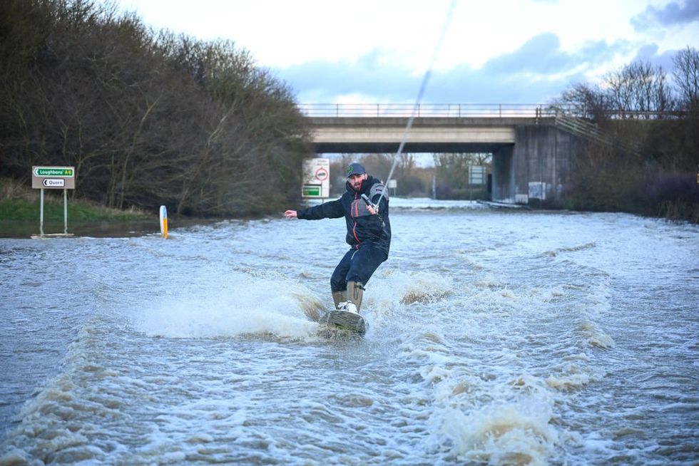 Man wind surfing on flooded water