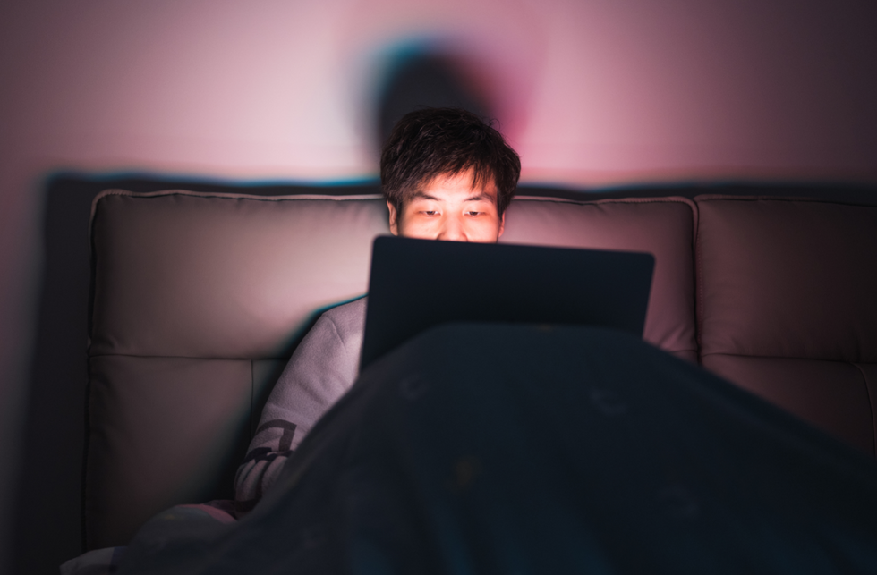 Man working late from his bed