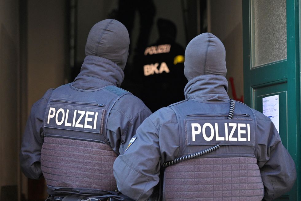 Masked German police officers enter a house