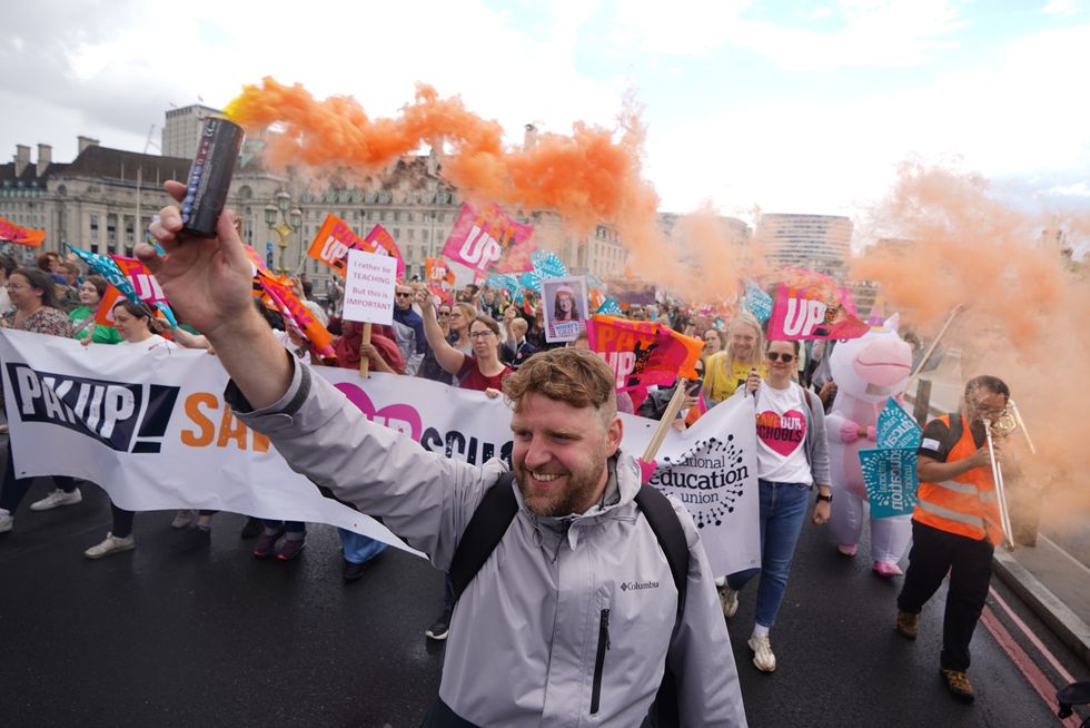 Members of the National Education Union (NEU) take part in a rally through Westminster