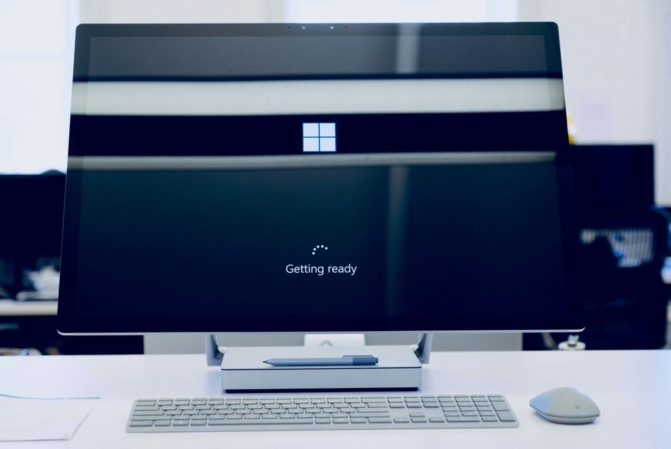 microsoft surface desktop PC pictured on a table with the Windows Getting Ready loading screen while an update is applied 