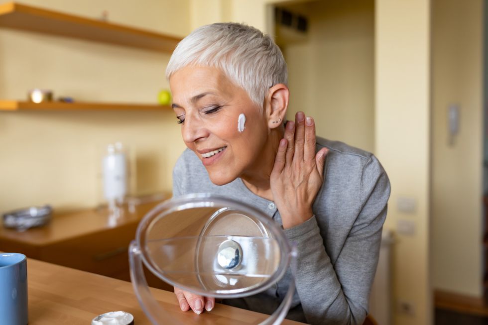 Middle-aged woman applying a skin care cream