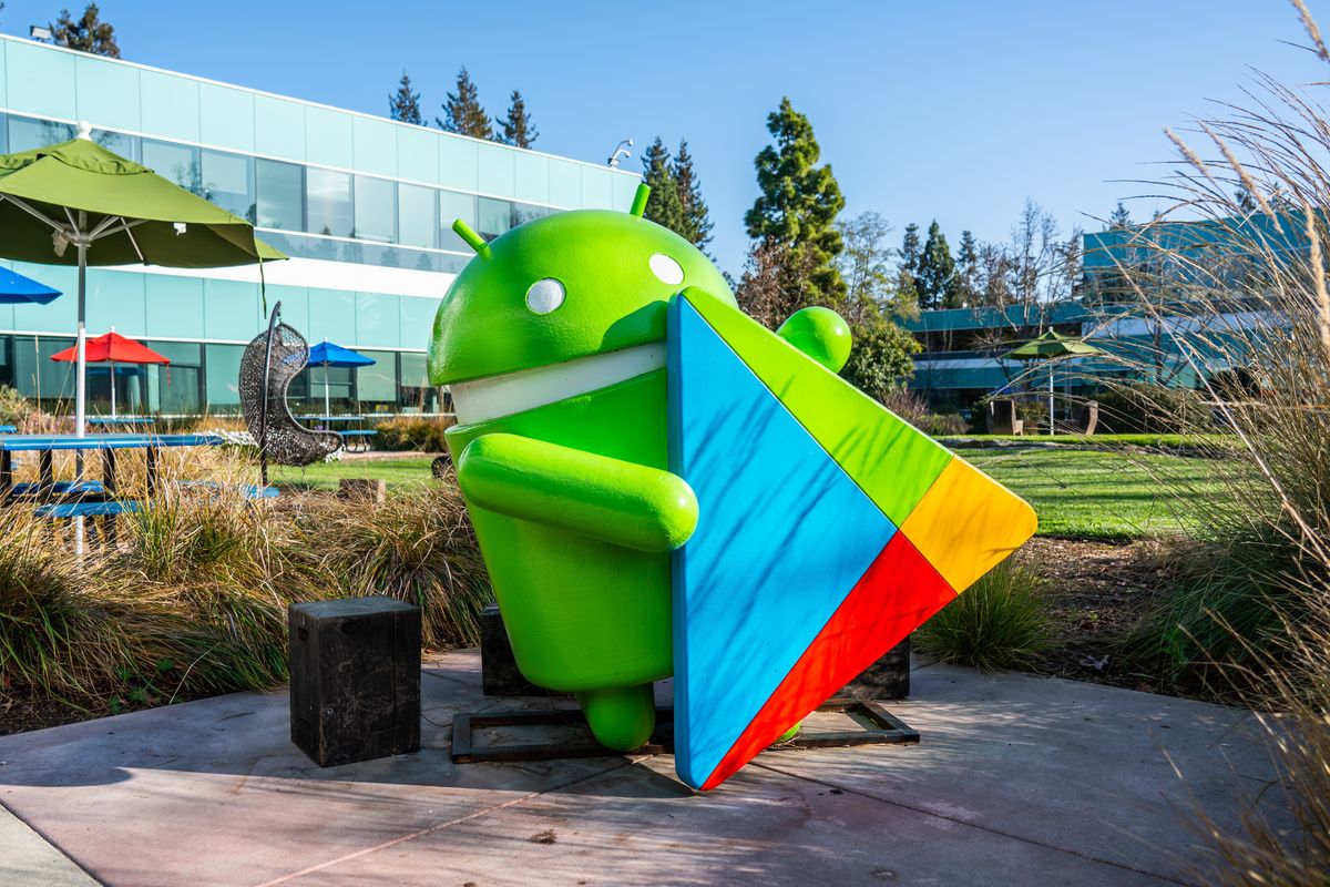 model of the google android mascot pictured holding the logo for the play store in the google campus in california 