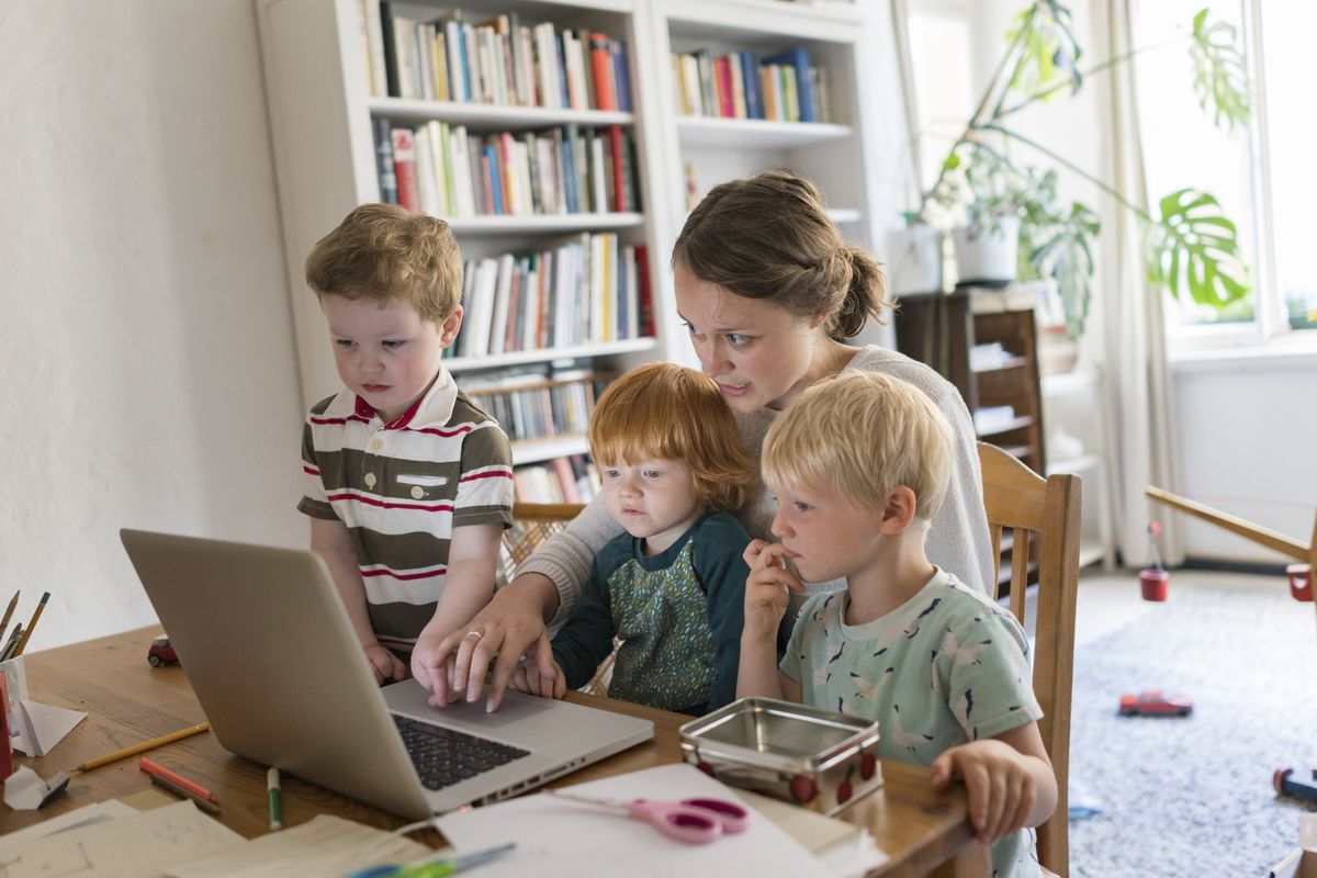 Mother at laptop with kids