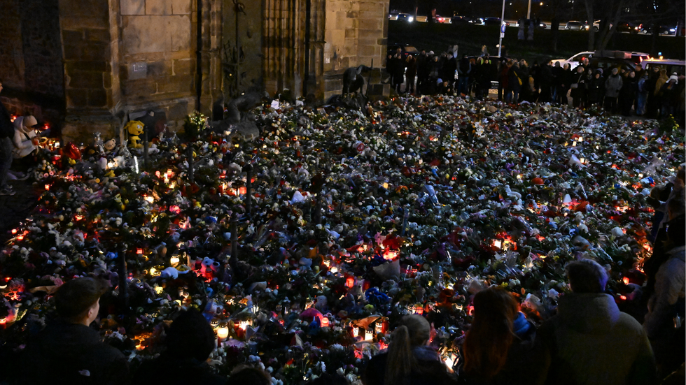 Mourners stand around a makeshift memorial of flowers and candles for the victims of a car-ramming attack on a Christmas market in Magdeburg