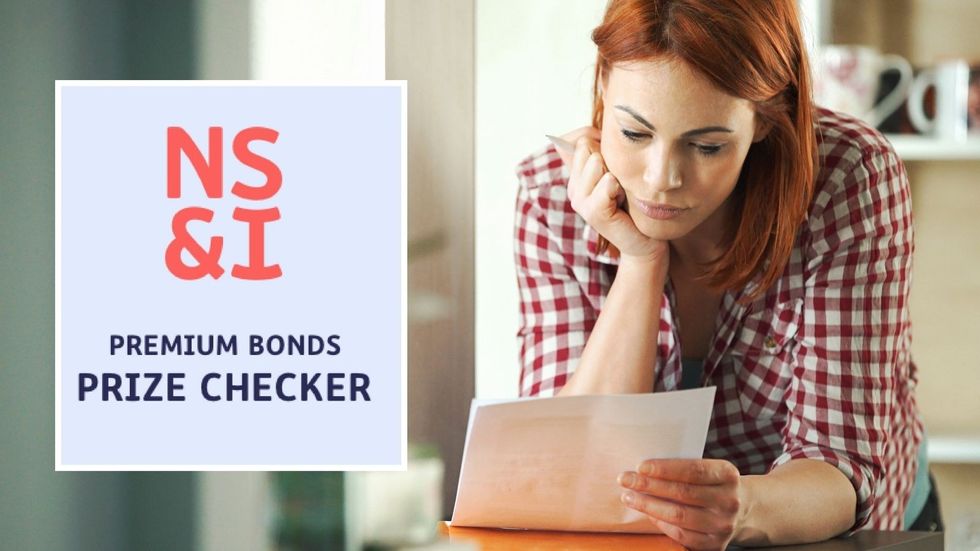 NS&I Premium Bonds prize checker logo and saver looks at letter while leaning on kitchen worktop