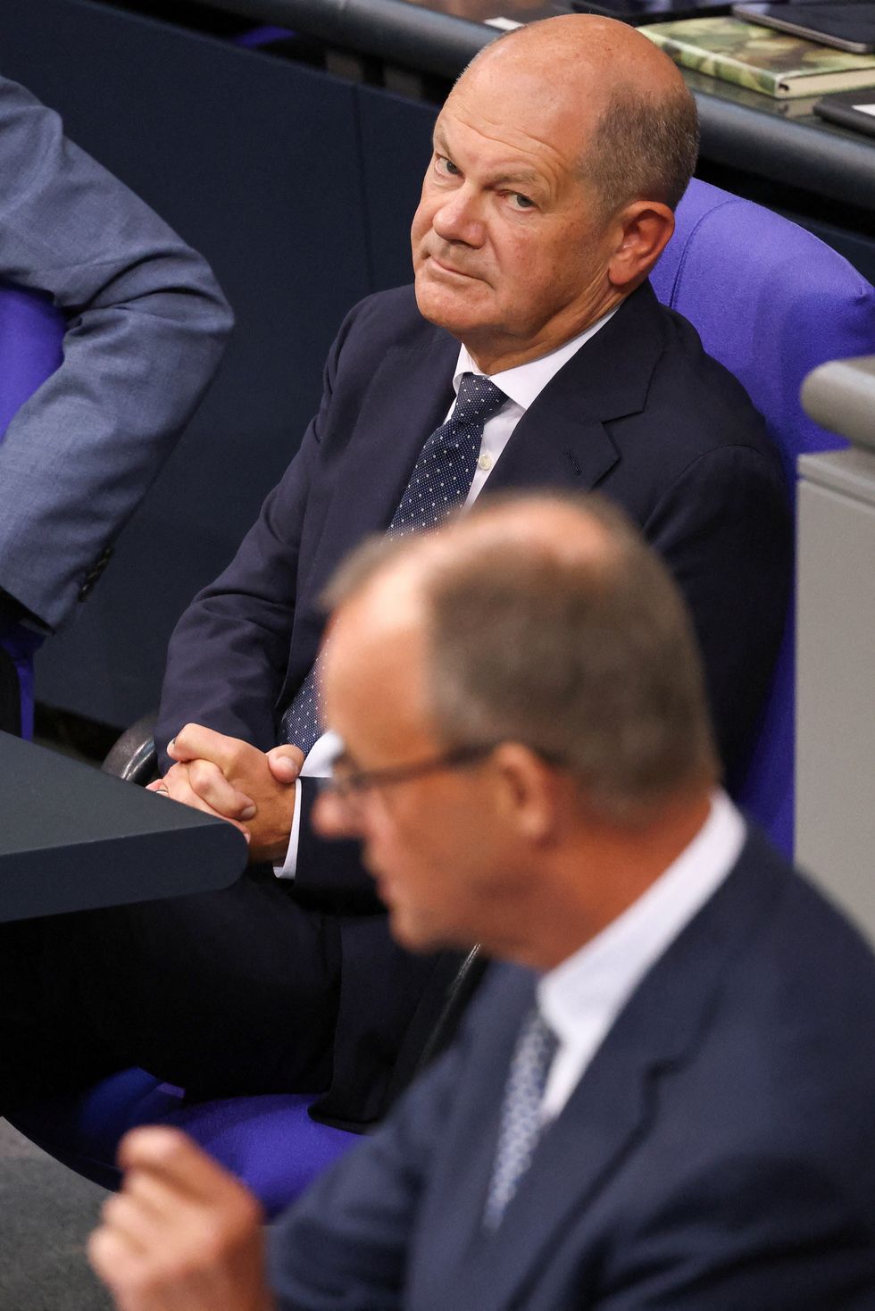 Olaf Scholz looking at Friedrich Merz