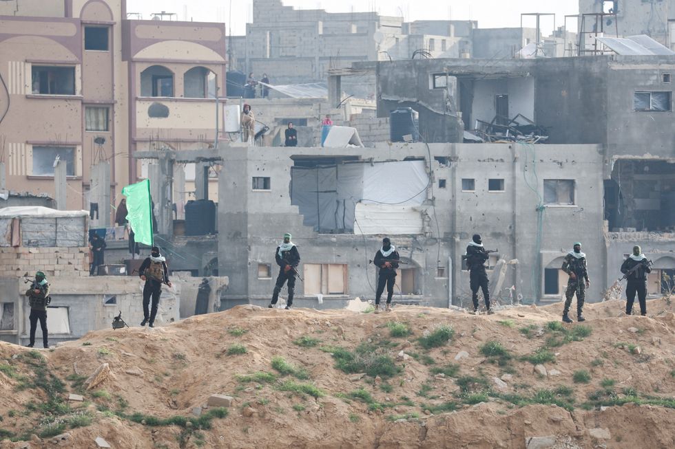 Palestinian Hamas militants keep guard on the day Hamas hands over deceased hostages u200b