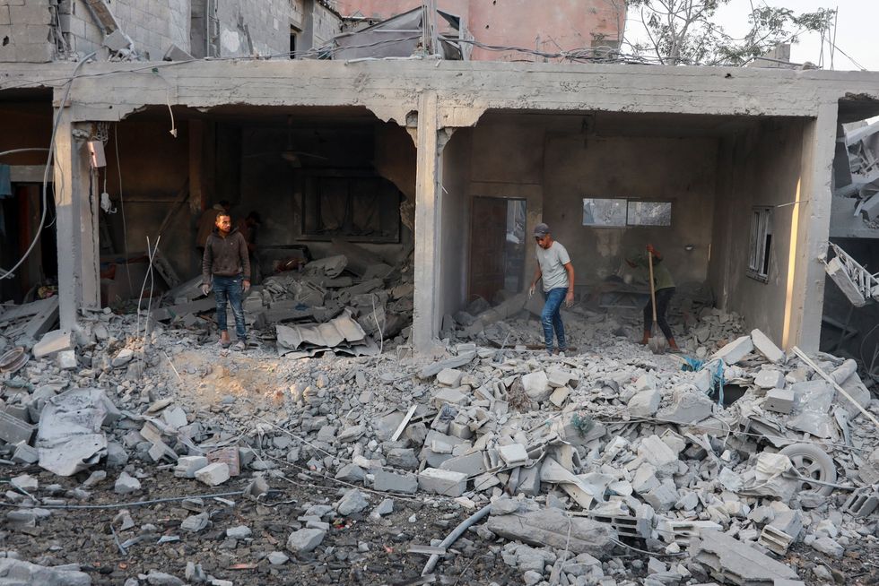 Palestinians inspect the site of an Israeli strike on a house, amid the Israel-Hamas conflict, in Nuseirat in the central Gaza Strip