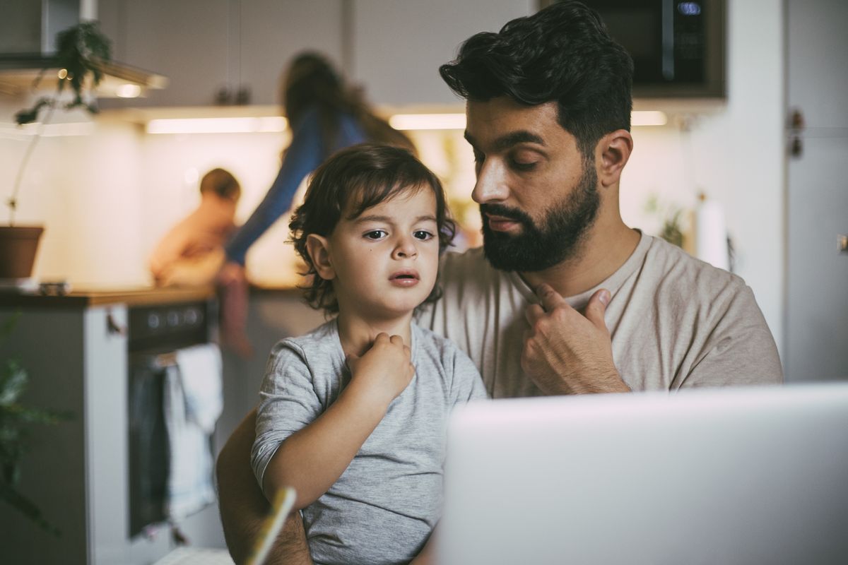 Parent and child look at laptop while deciding whether to buy Premium Bonds