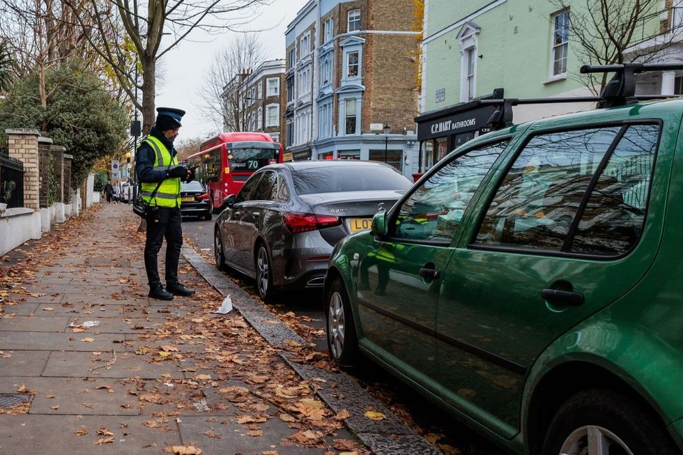 Parking attendant looking at parked cars