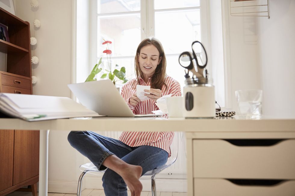 Pension saver looks at phone while at desk