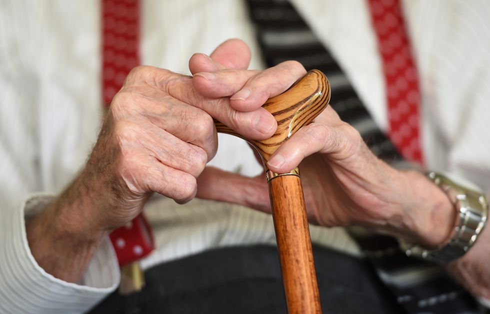 Pensioner holds walking stick