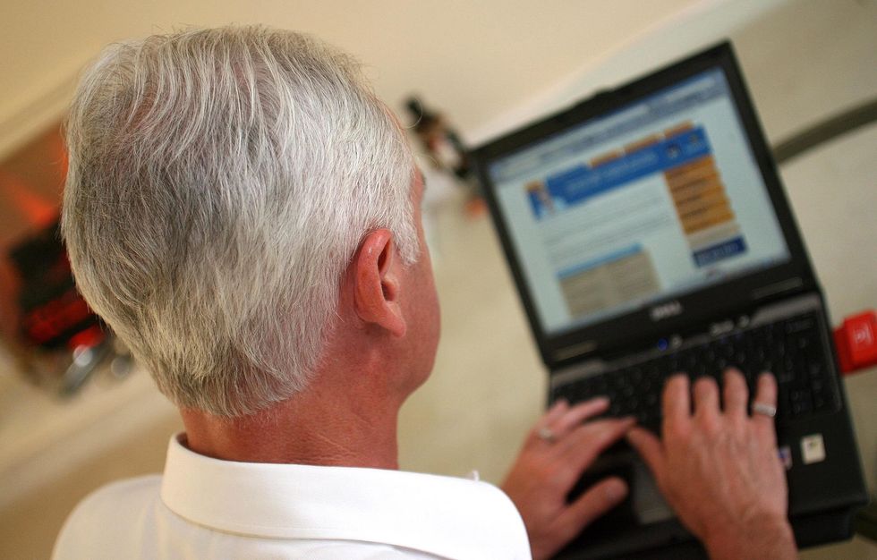 Pensioner looks at laptop