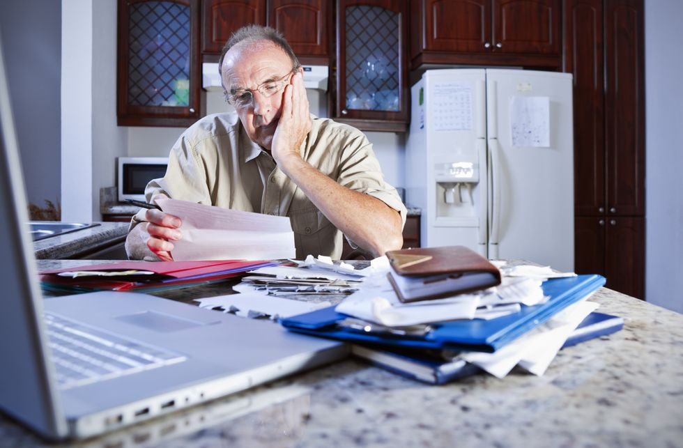 Pensioner looks at letter looking worried