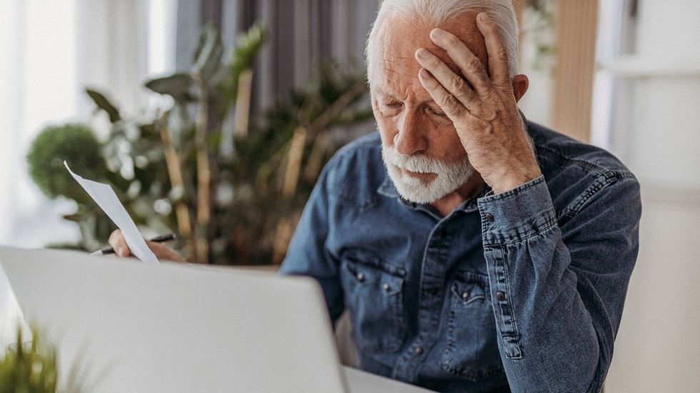 Pensioner sad at laptop