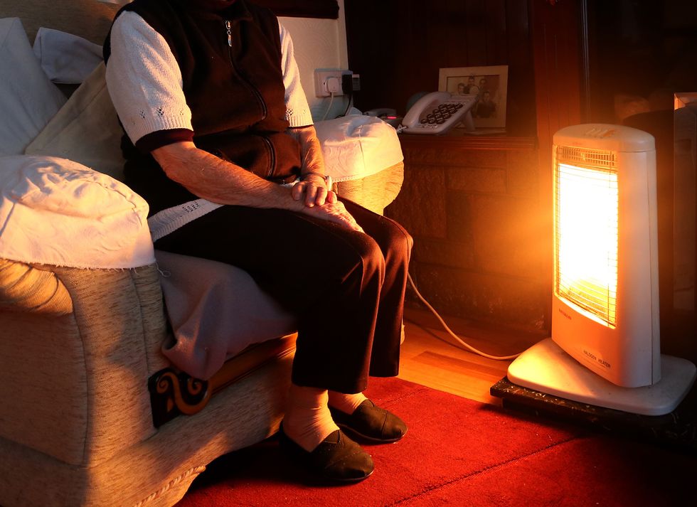 Pensioner sitting next to heater