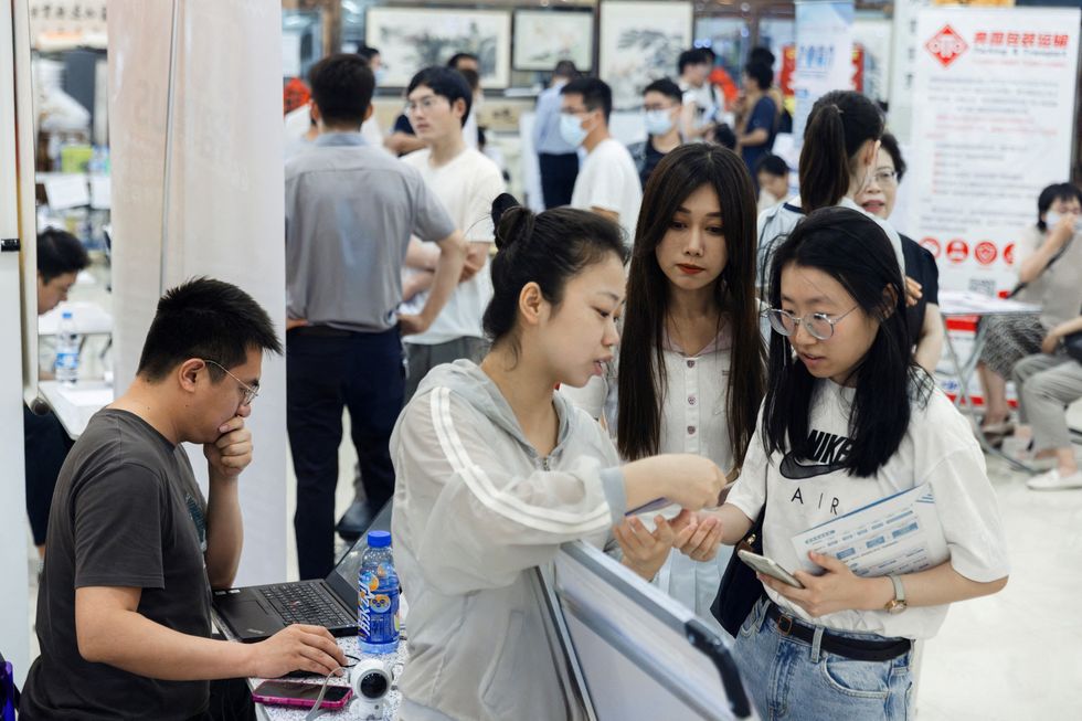 People attend a job fair in a mall in Beijing, China