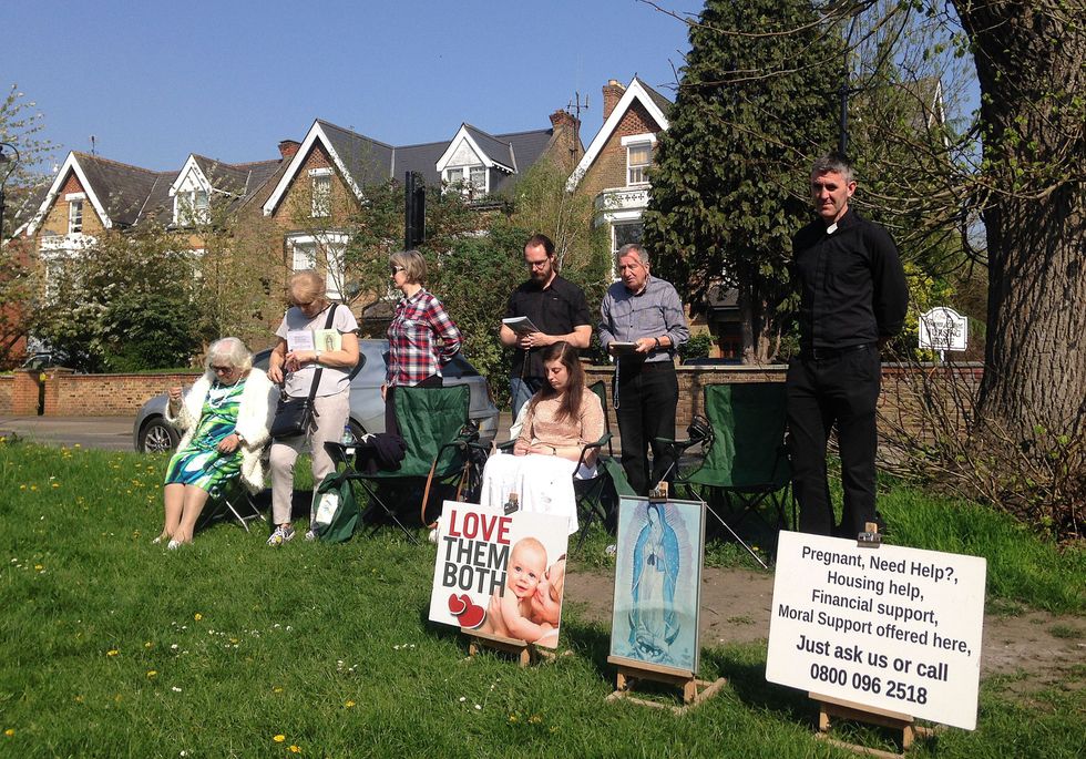 People attend an anti-abortion pro-life vigil on the street 