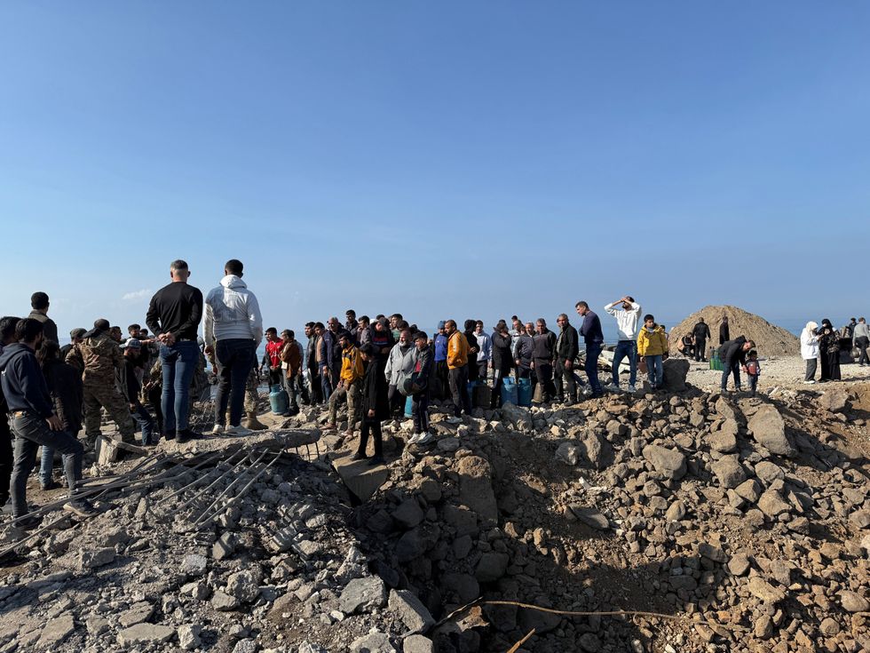 People gather at the Lebanese-Syrian border crossing of Arida, after Syrian rebels announced that they have ousted Syria's Bashar al-Assad, in Lebanon