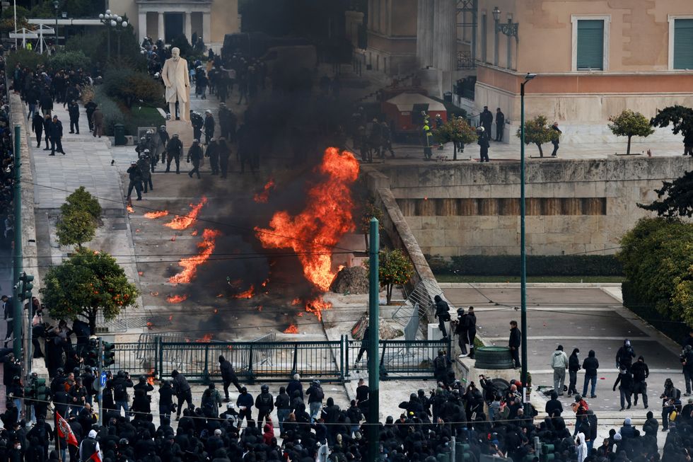 People gather next to fire, near the Greek parliament during a protest,\u200b