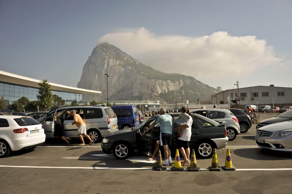 People get out of their cars cool down as they wait in traffic queues on the Gibraltar side of the Spanish border