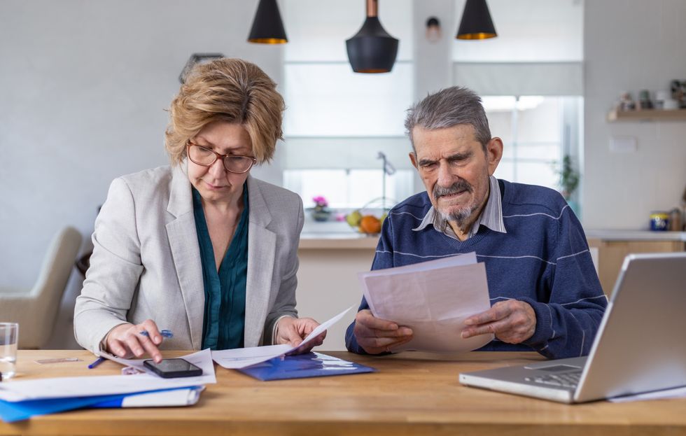 People look at bank statements beside phone and laptop