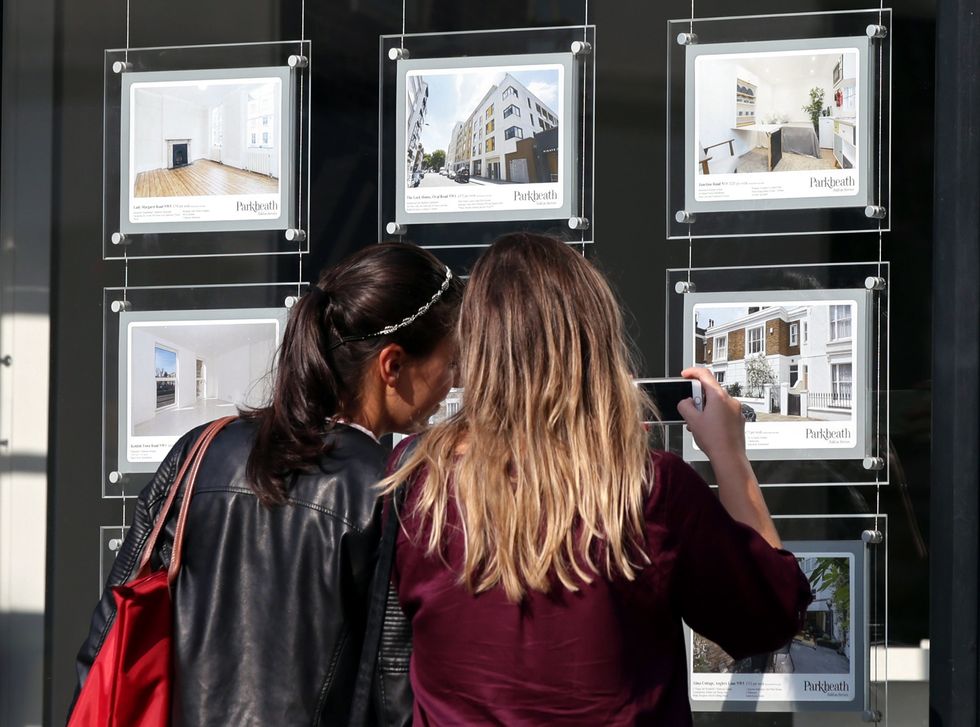 People look at houses for sale in the window