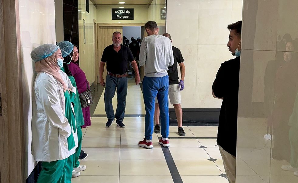 People stand outside a morgue at a hospital in Sidon, Lebanon