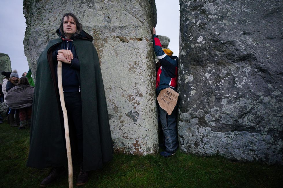 People take part in the winter solstice celebrations during sunrise at the Stonehenge prehistoric monument on Salisbury Plain