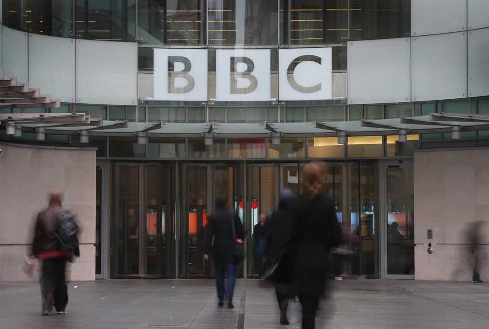 People walk near the entrance to BBC Broadcasting House on October 22, 2012