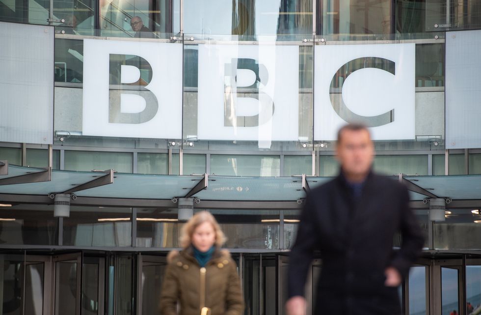 people walking outside of the BBC headquarters in London