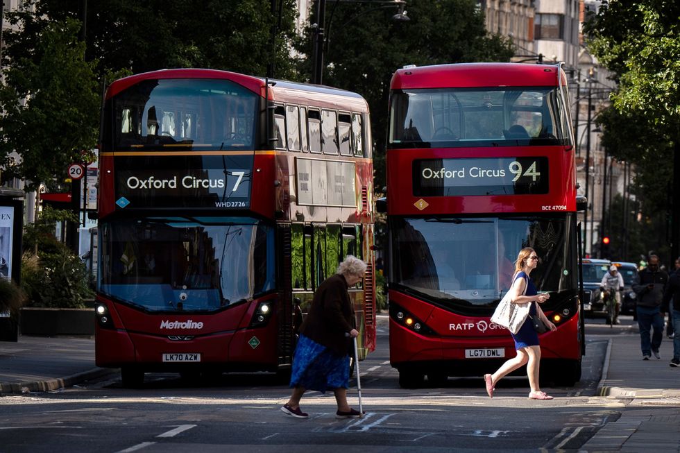 Person crossing the road and buses on Oxford Street, London