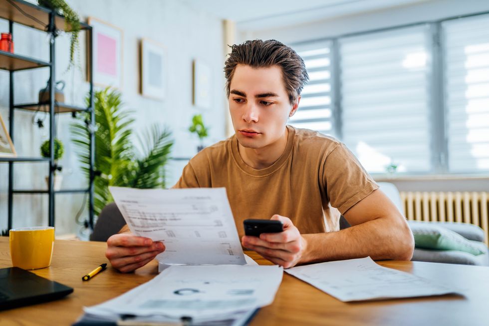 Person looks at calculator and document