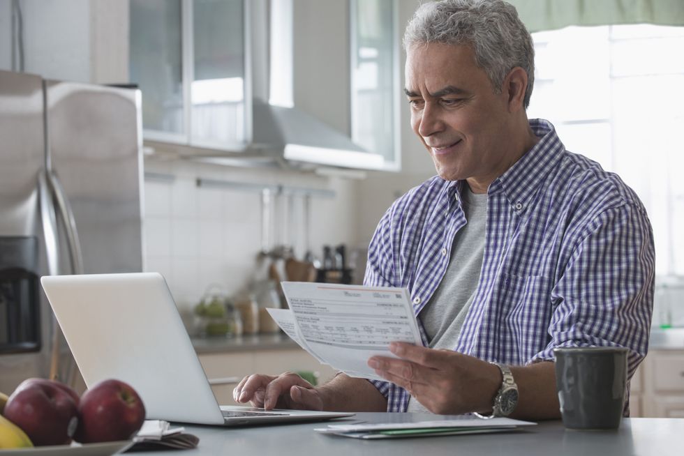 Person looks at documents and laptop