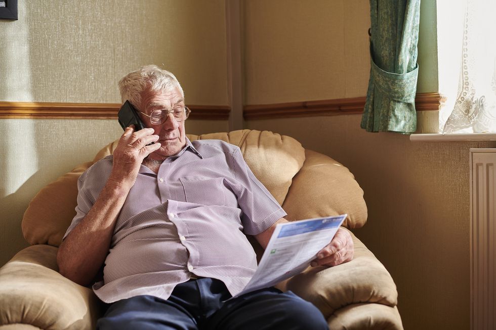 Person looks at energy bill while on the phone