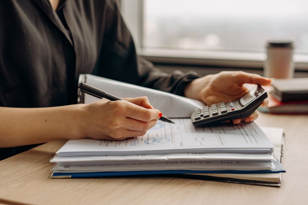 Person looks at finances with calculator in hand