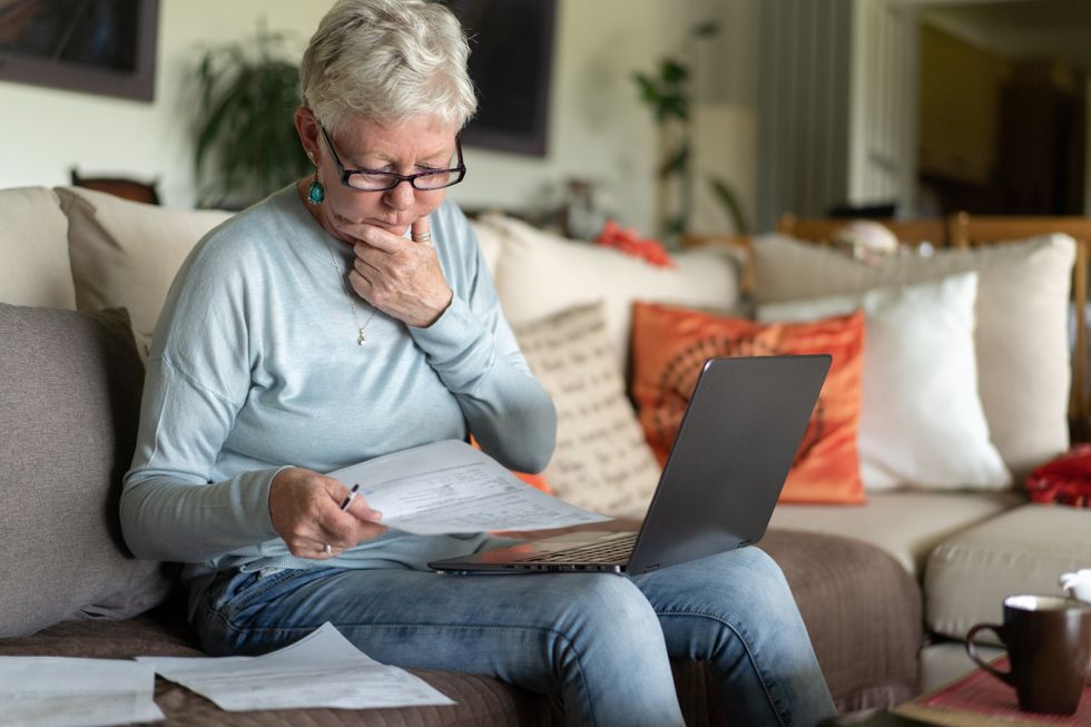 Person looks- at letters and laptop