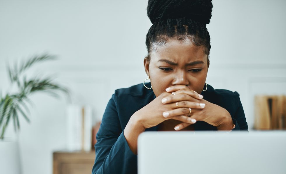 Person looks worried at laptop