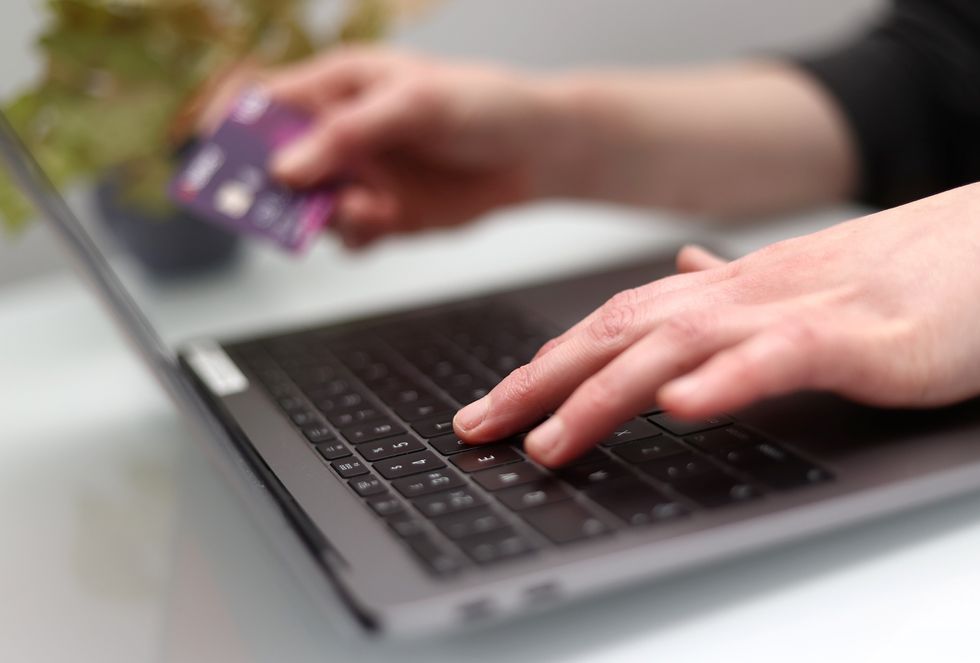 Person on laptop with NatWest card in background