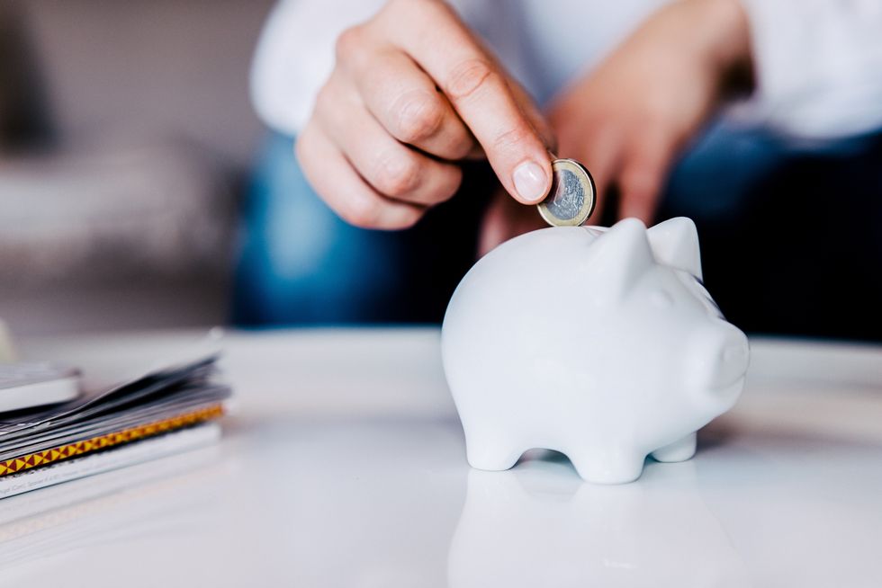 Person saving money in piggy bank